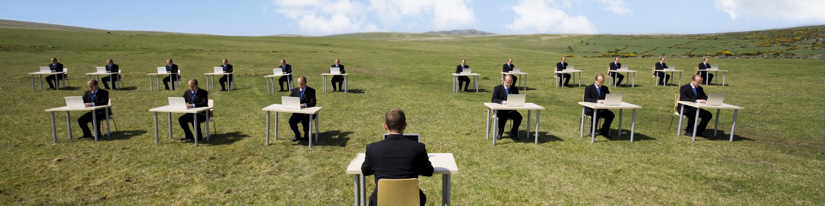 People training at desks in a field